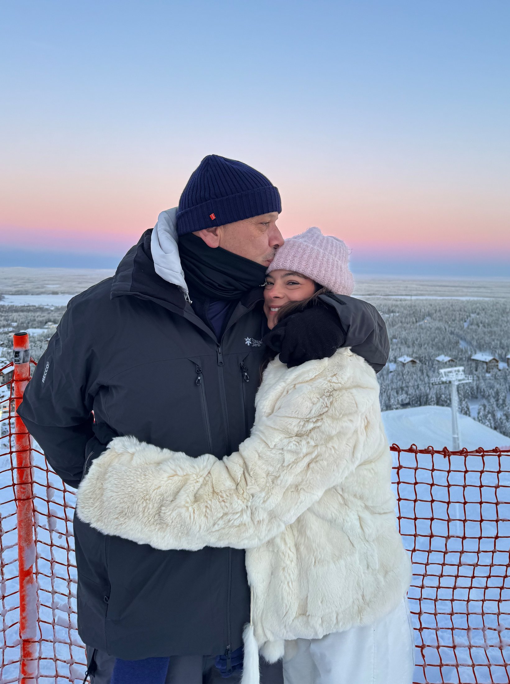 Familia — abrazo al atardecer en la nieve